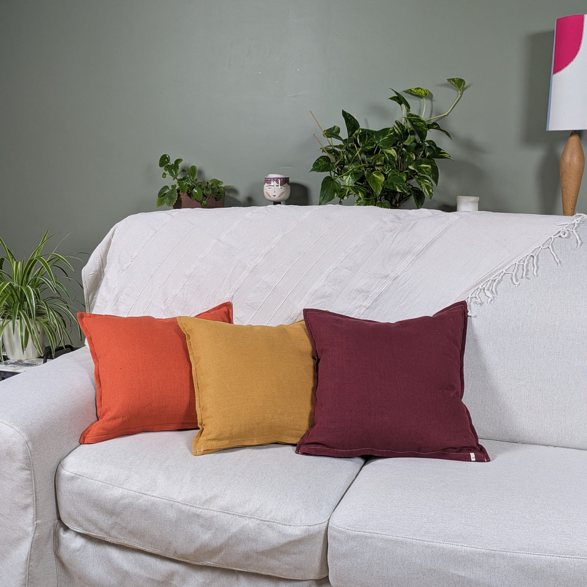 Housses de coussin en lin moutarde, terracotta et bordeaux sur canapé blanc -  collection Mokiko