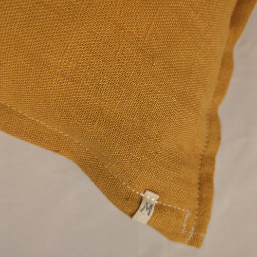 Détail texture lin français moutarde, surpiqûre écrue — housse de coussin Mokiko
