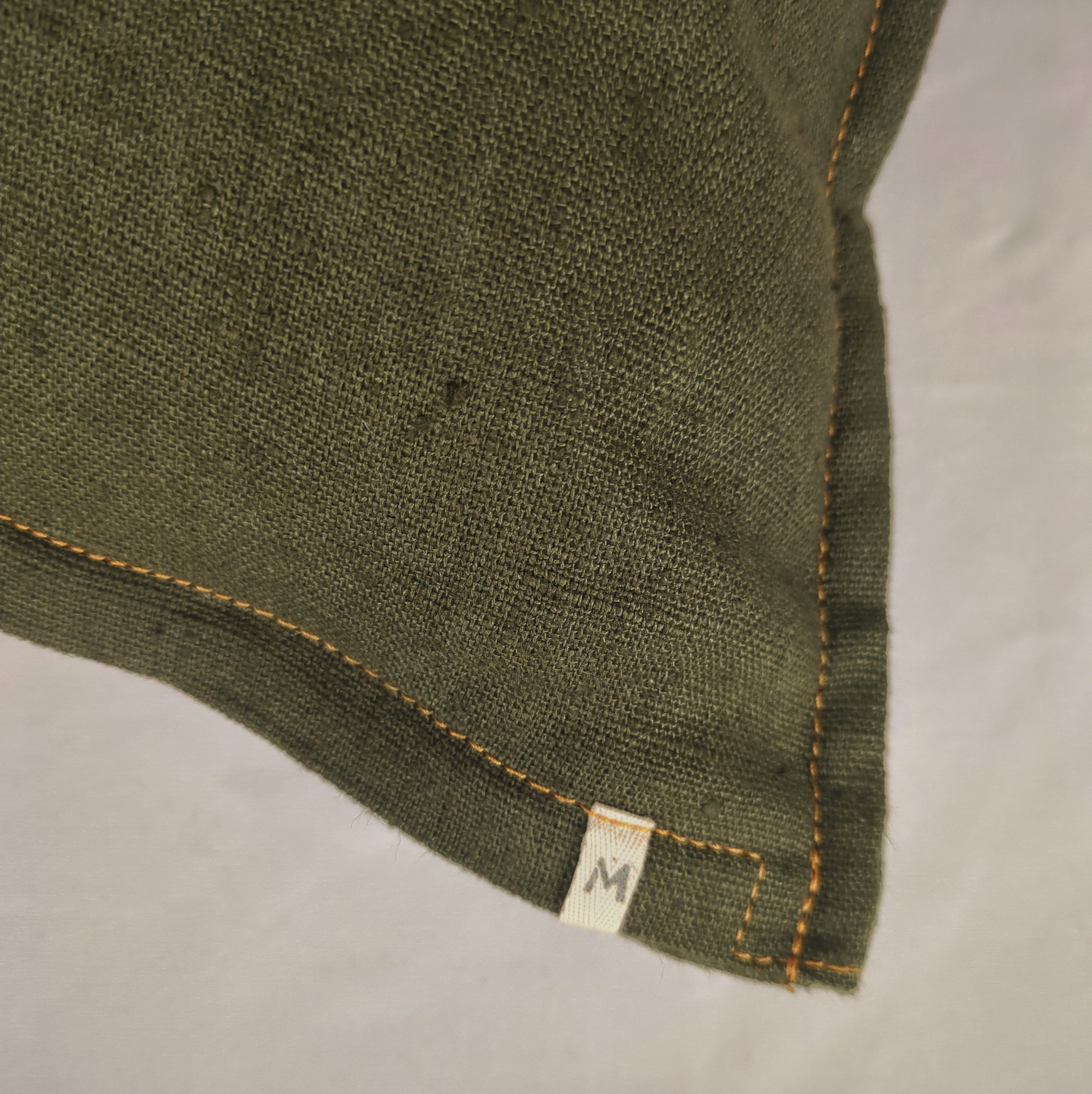 Détail texture lin français kaki, surpiqûre moutarde - housse de coussin Mokiko