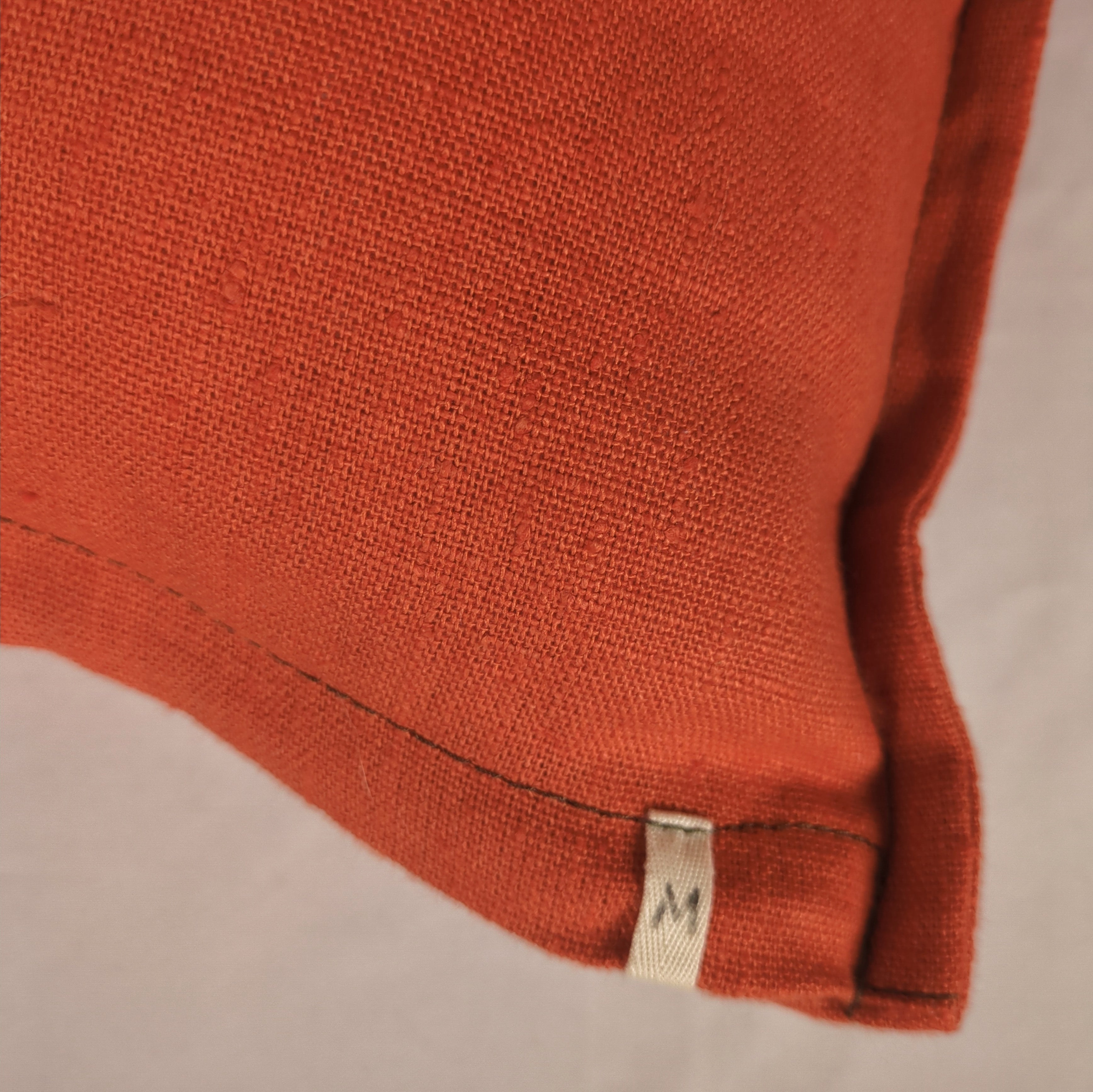 Détail texture lin français orange, surpiqûre kaki - housse de coussin Mokiko"